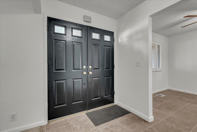 30 S Cambridge Dr, Lemoore, CA 93245 - entryway featuring a textured ceiling, light tile patterned floors, ceiling fan, and baseboards