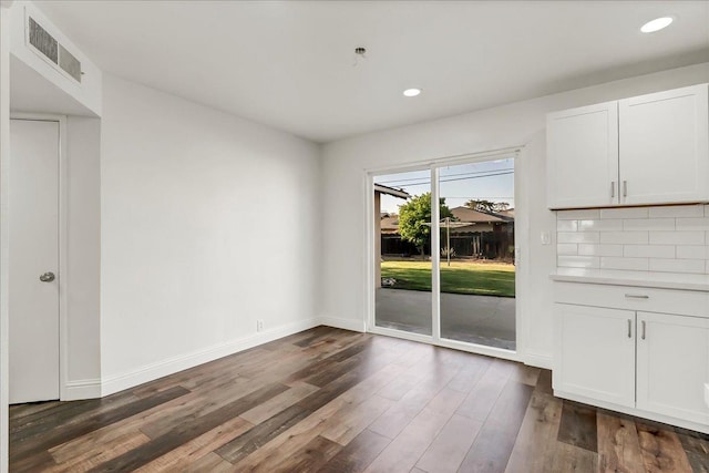 230 E Sycamore Dr, Hanford, CA 93230 - unfurnished dining area with dark wood-style flooring, visible vents, recessed lighting, and baseboards