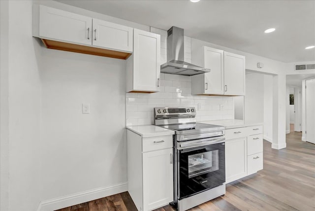 230 E Sycamore Dr, Hanford, CA 93230 - kitchen with electric stove, baseboards, light wood-style flooring, and wall chimney exhaust hood