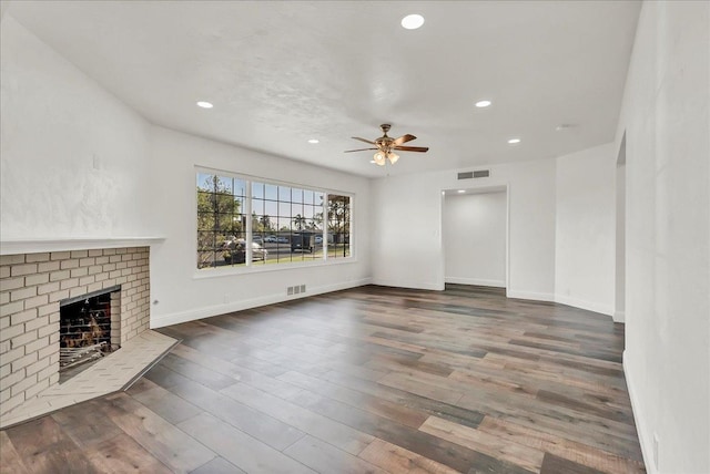 230 E Sycamore Dr, Hanford, CA 93230 - unfurnished living room featuring wood finished floors, visible vents, ceiling fan, and a brick fireplace
