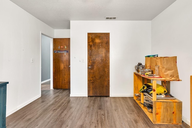 interior space with baseboards, visible vents, and wood finished floors
