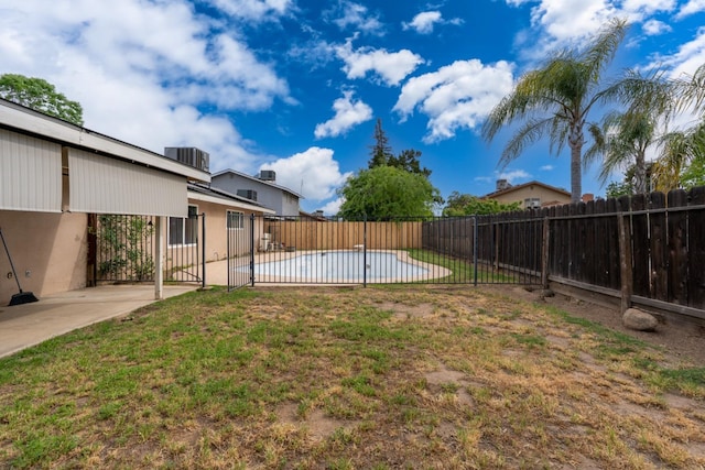 view of yard with a fenced backyard, a fenced in pool, and a patio area
