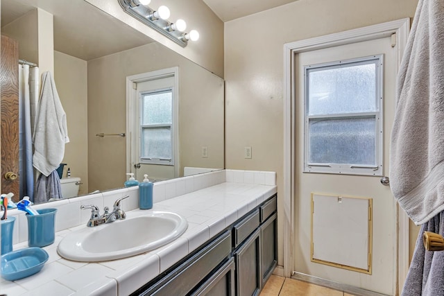 bathroom featuring toilet, tile patterned floors, a wealth of natural light, and vanity