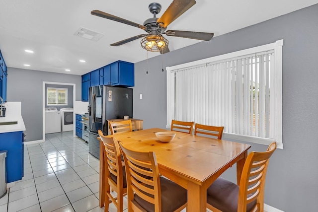 dining room featuring light tile patterned floors, independent washer and dryer, visible vents, baseboards, and a ceiling fan