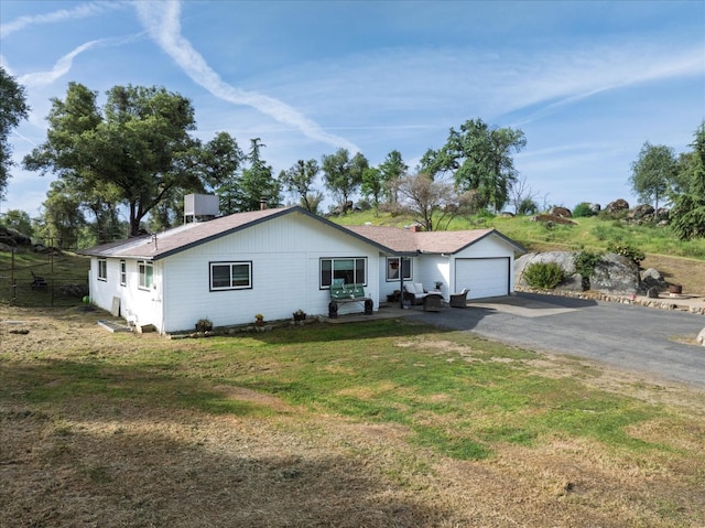single story home with central air condition unit, aphalt driveway, a front lawn, and an attached garage