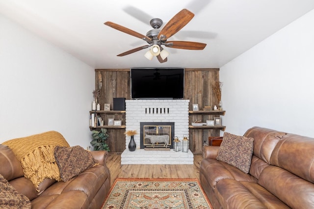 living room with ceiling fan, wood finished floors, and a fireplace