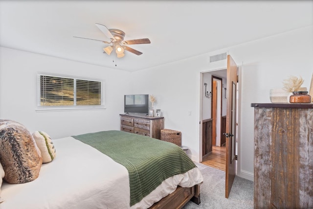 bedroom with a ceiling fan, visible vents, light carpet, and baseboards