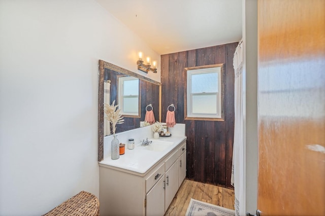 full bath with wooden walls, wood finished floors, and vanity