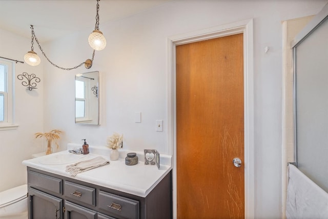 bathroom featuring vanity, toilet, and an enclosed shower