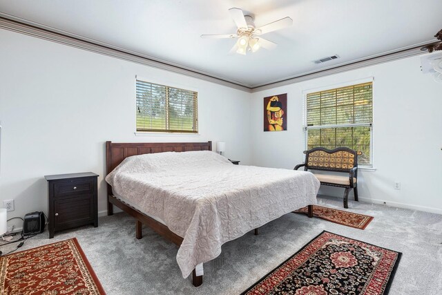 bedroom with multiple windows, visible vents, crown molding, and light carpet