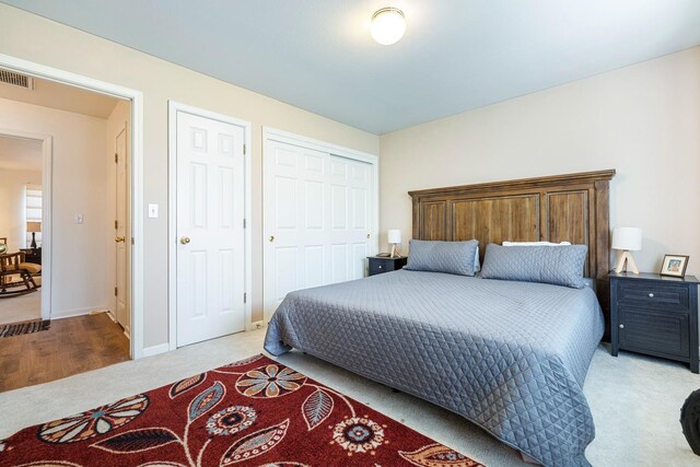 carpeted bedroom featuring visible vents, baseboards, and a closet