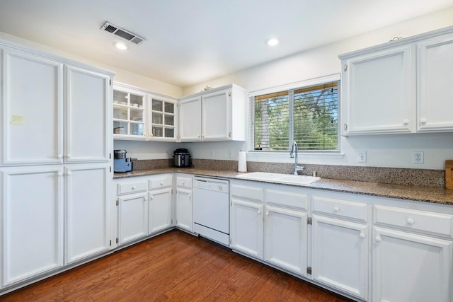 kitchen featuring a sink, white dishwasher, dark wood-type flooring, visible vents, and white cabinetry