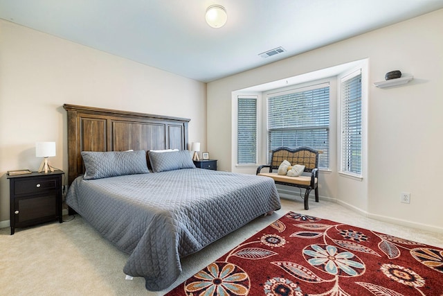 bedroom featuring baseboards, visible vents, and light colored carpet