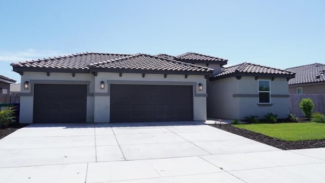 mediterranean / spanish-style house with driveway, an attached garage, fence, and stucco siding