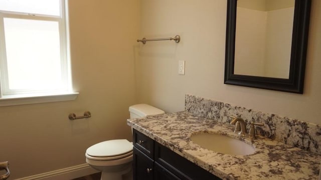 bathroom featuring vanity, toilet, and baseboards