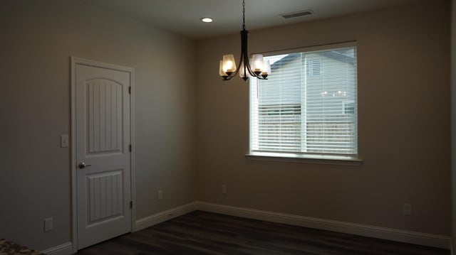 empty room featuring recessed lighting, a notable chandelier, dark wood-type flooring, visible vents, and baseboards