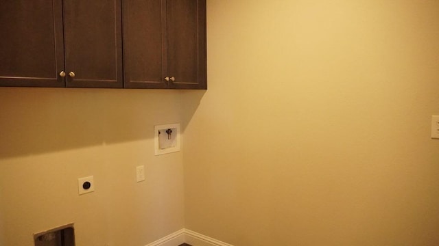 clothes washing area with hookup for an electric dryer, cabinet space, washer hookup, and baseboards