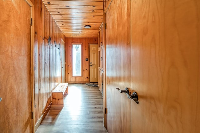 interior space with wooden walls, wooden ceiling, and wood finished floors