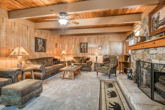 carpeted living area with wood walls, beam ceiling, and wooden ceiling