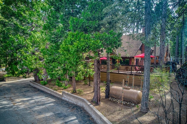 exterior space featuring a deck and a shingled roof