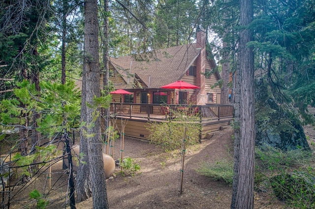 back of house featuring a deck and a chimney