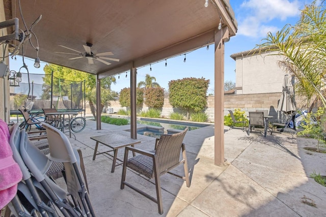 view of patio / terrace featuring a fenced backyard, ceiling fan, a fenced in pool, and a trampoline