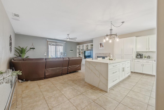 kitchen featuring light tile patterned flooring, visible vents, white cabinets, and open floor plan