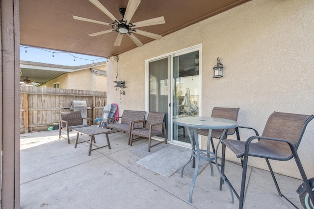 view of patio featuring a ceiling fan, outdoor dining area, and fence