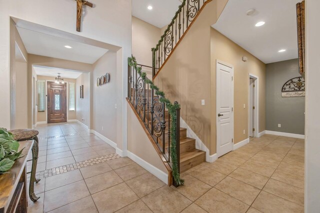 foyer featuring baseboards, recessed lighting, light tile patterned floors, and stairs