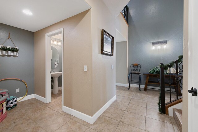 hallway with light tile patterned floors and baseboards