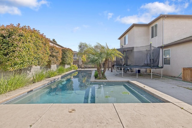 view of pool with a trampoline, a fenced backyard, a fenced in pool, and a patio area