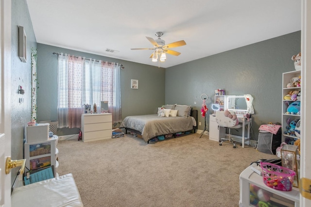 carpeted bedroom featuring baseboards, visible vents, and ceiling fan