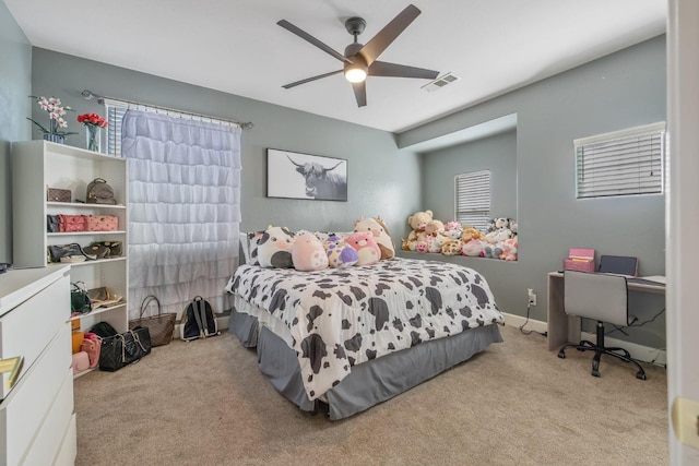 carpeted bedroom featuring multiple windows, ceiling fan, and visible vents