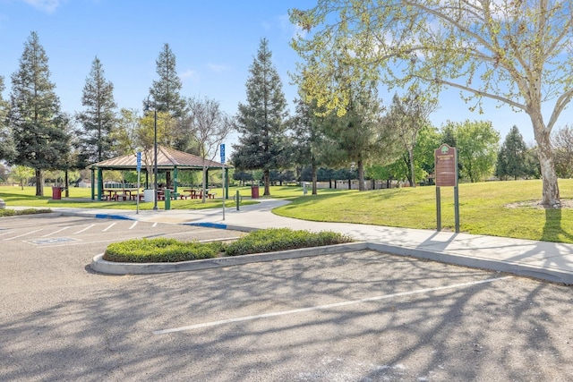 view of home's community with a gazebo, uncovered parking, and a lawn