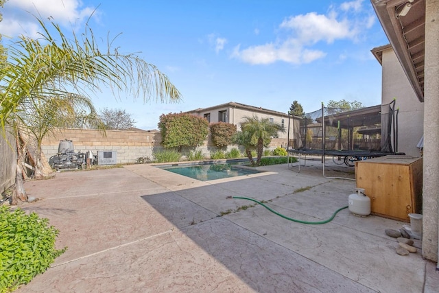 view of swimming pool featuring a fenced backyard, a patio area, a fenced in pool, and a trampoline