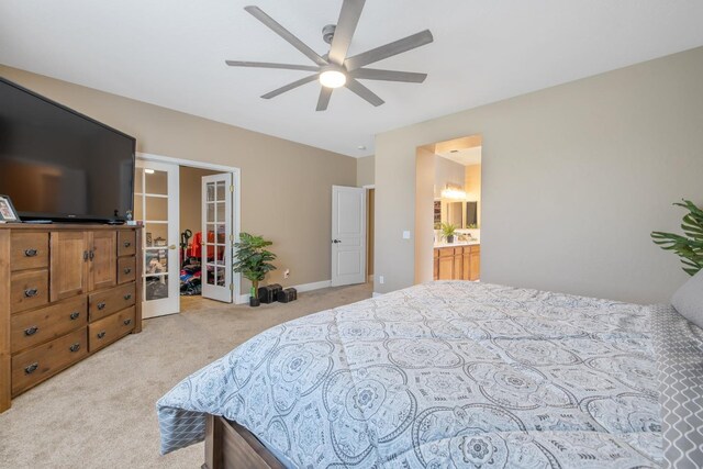 bedroom with a closet, a ceiling fan, light colored carpet, french doors, and a spacious closet