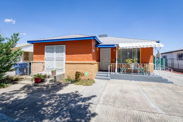 view of front of property featuring stucco siding and fence