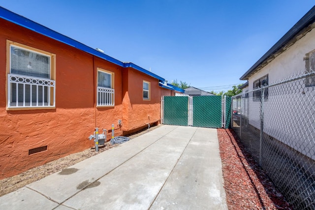 view of property exterior with fence, a patio, and crawl space