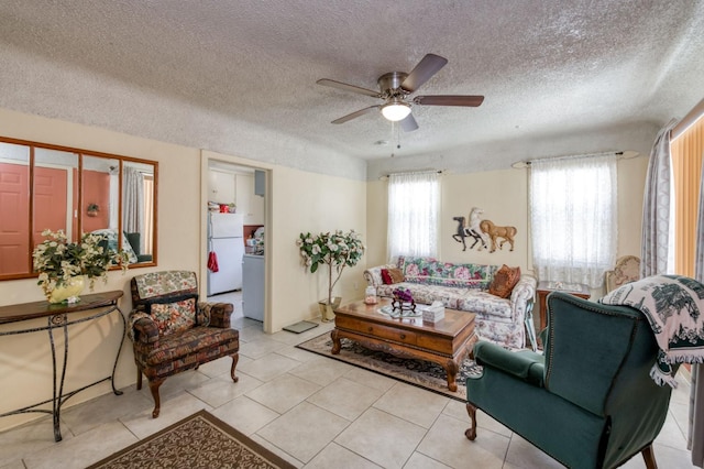 living area with a textured ceiling, ceiling fan, and light tile patterned flooring