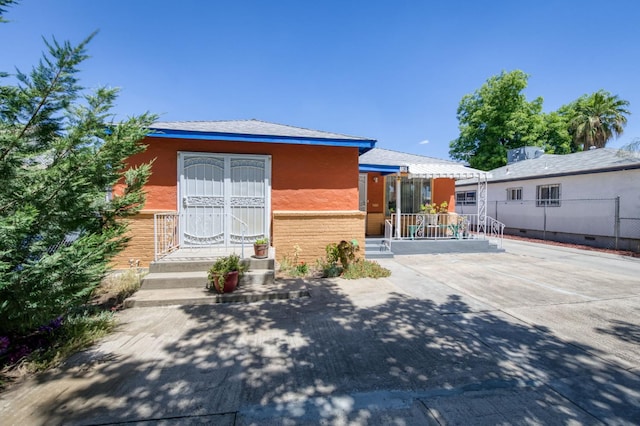 view of front of home featuring fence and stucco siding