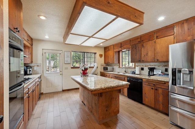 kitchen featuring recessed lighting, black appliances, a sink, and decorative backsplash