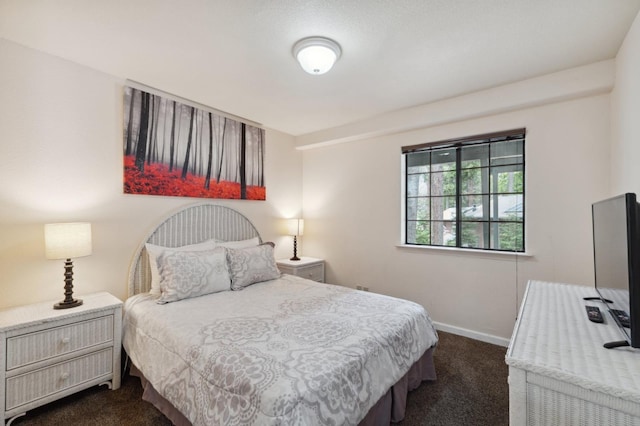 bedroom with baseboards and dark carpet