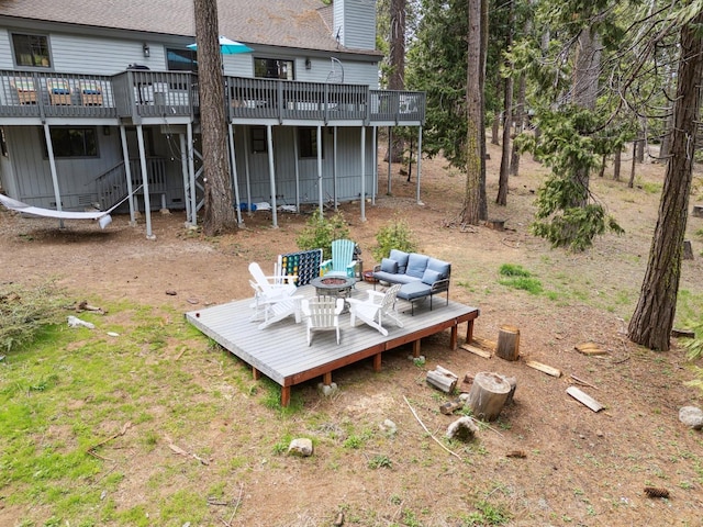 view of yard featuring a deck and an outdoor living space with a fire pit