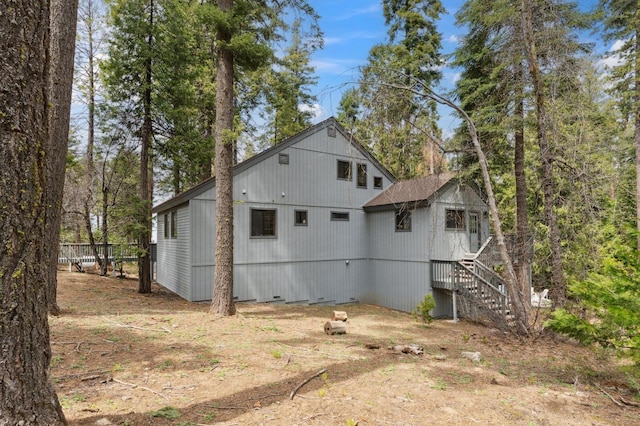 view of side of home with fence, stairs, and crawl space