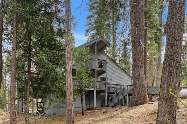 back of property with stairs, crawl space, a wooden deck, and a balcony