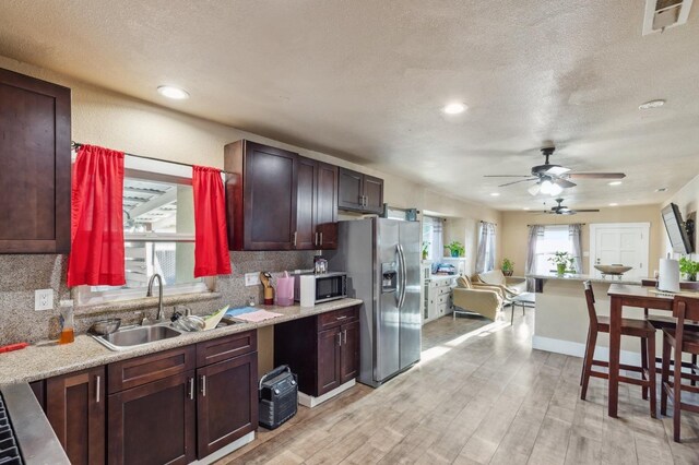 555 S Sierra Vista Ave, Fresno, CA 93702 - kitchen featuring decorative backsplash, a sink, appliances with stainless steel finishes, light wood finished floors, and a ceiling fan