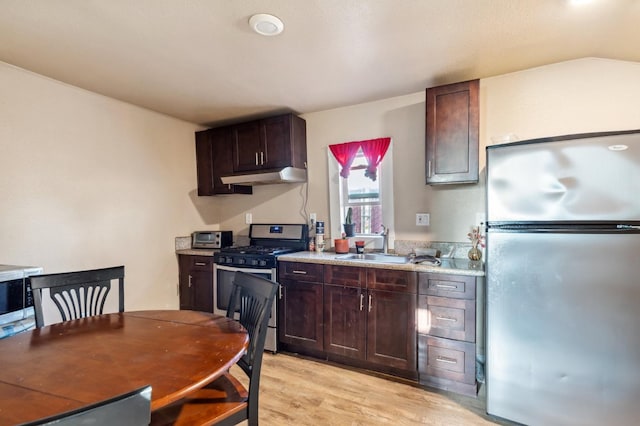 555 S Sierra Vista Ave, Fresno, CA 93702 - kitchen with a sink, stainless steel appliances, dark brown cabinets, light countertops, and under cabinet range hood