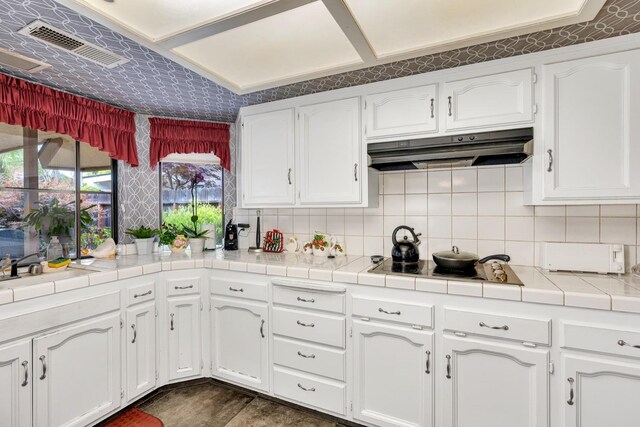 167 W Quincy Ave, Fresno, CA 93711 - kitchen featuring backsplash, electric stovetop, white cabinetry, and under cabinet range hood