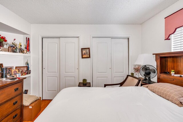 167 W Quincy Ave, Fresno, CA 93711 - bedroom featuring wood finished floors, a textured ceiling, and two closets