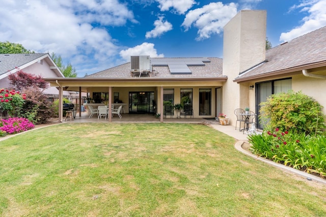167 W Quincy Ave, Fresno, CA 93711 - back of house featuring a patio area, cooling unit, a lawn, solar panels, and stucco siding